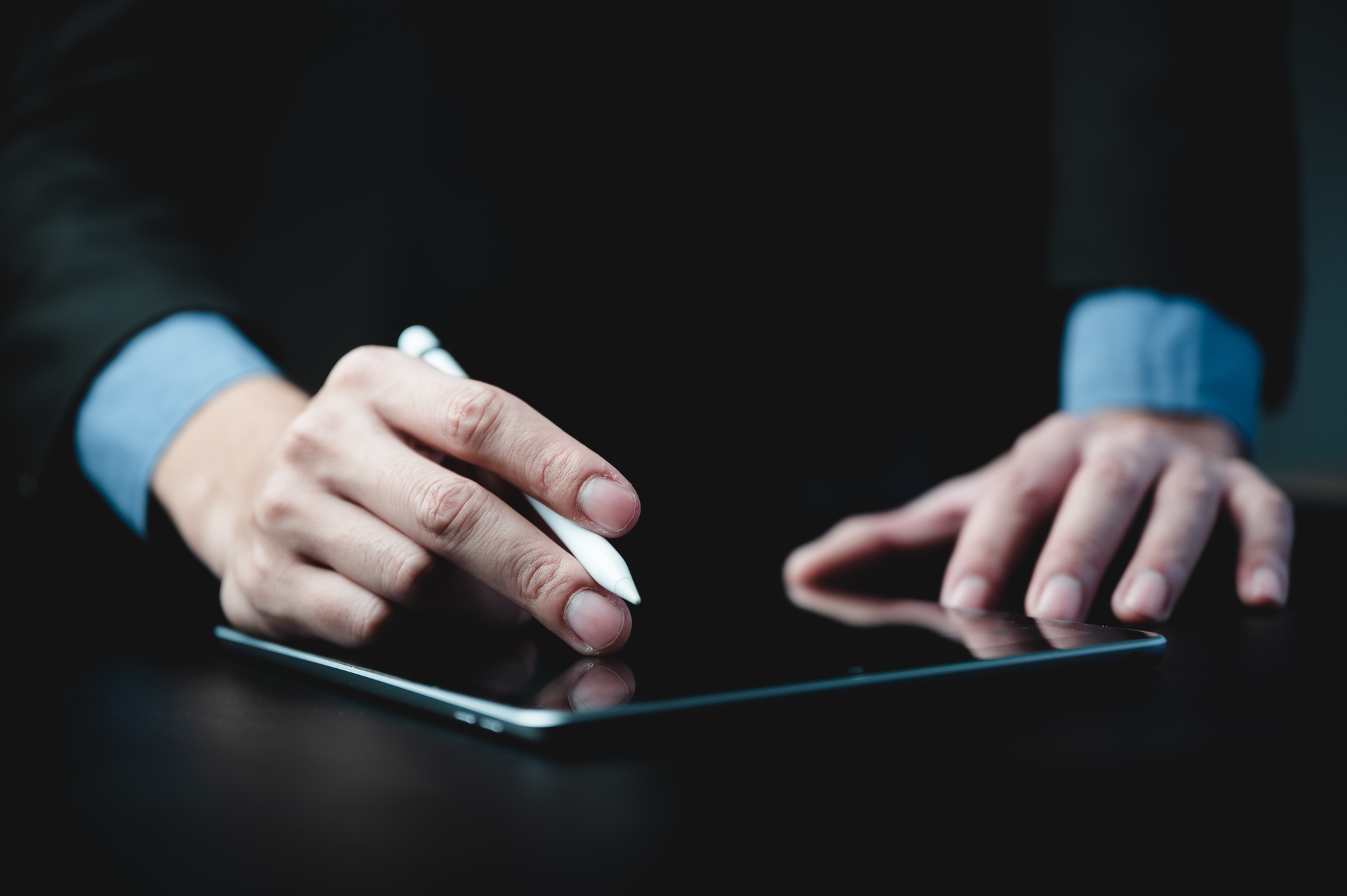 hands of a young successful male entrepreneur and businessman writing on digital tablet
