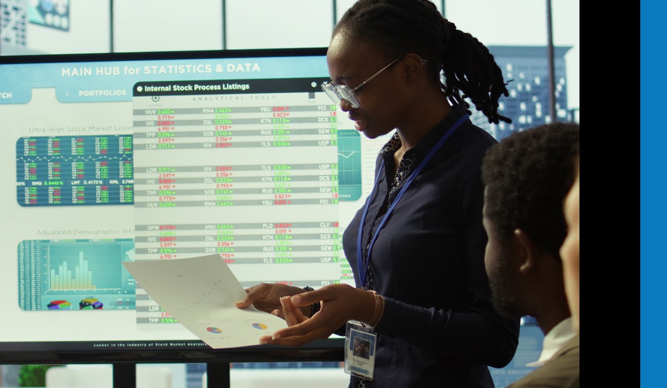 An NTT data analyst presenting a case using a screen and research document.