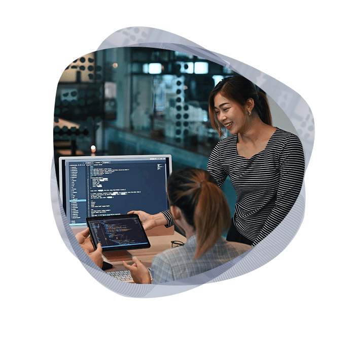 Two IT specialists from the Mint group working together on an intelligent automation solution at a workstation.