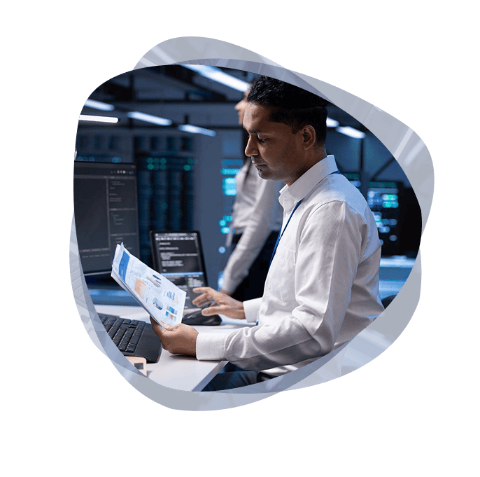 A business application specialist from the Mint Group, seated at his desk, looking at some data and working on a solution for a client.