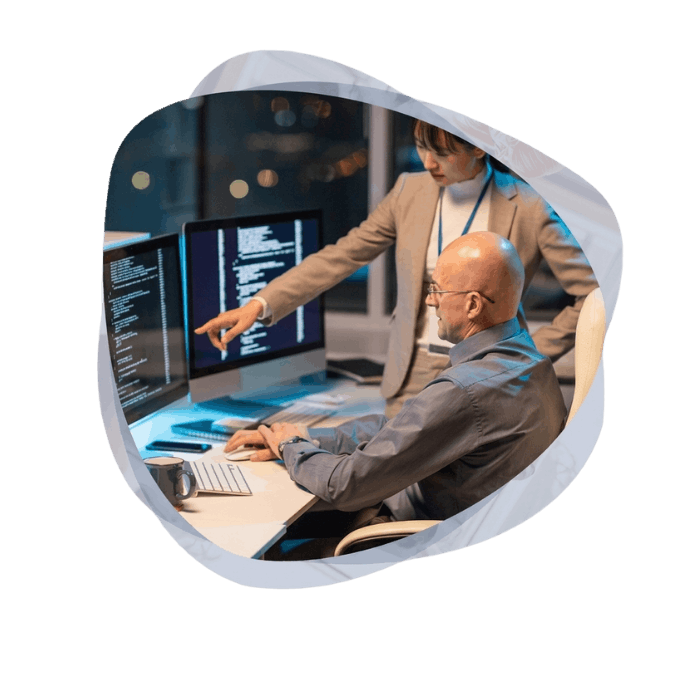 Developers collaborating at a workstation to build custom agents using Microsoft Agentic AI Development Services.
