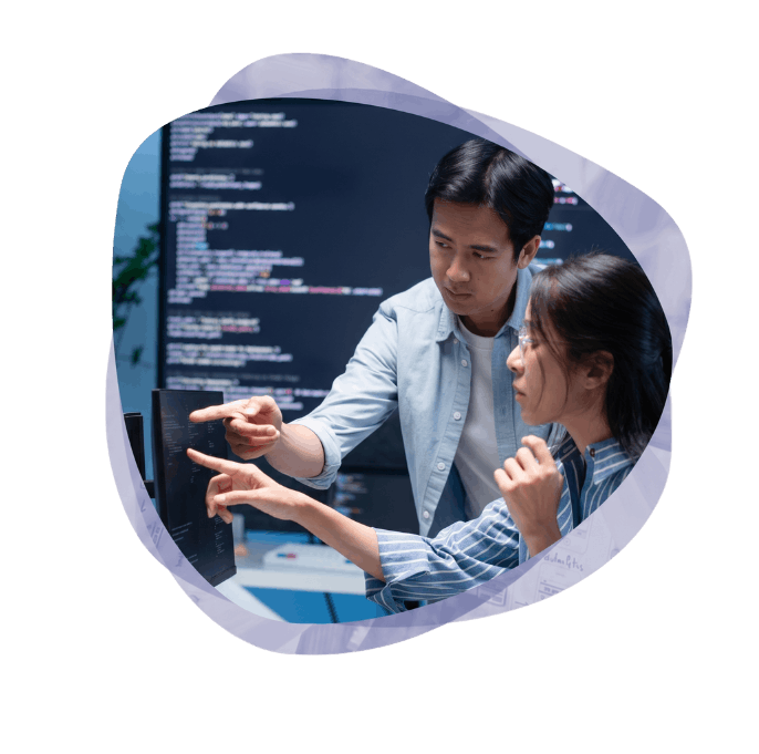 Two IT professionals collaborating and pointing at code on a vertical monitor while working on Azure integration services.