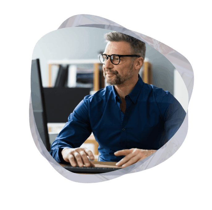 A professional working on client-facing portals and website modernisation, typing at a desktop computer to build custom enterprise applications.