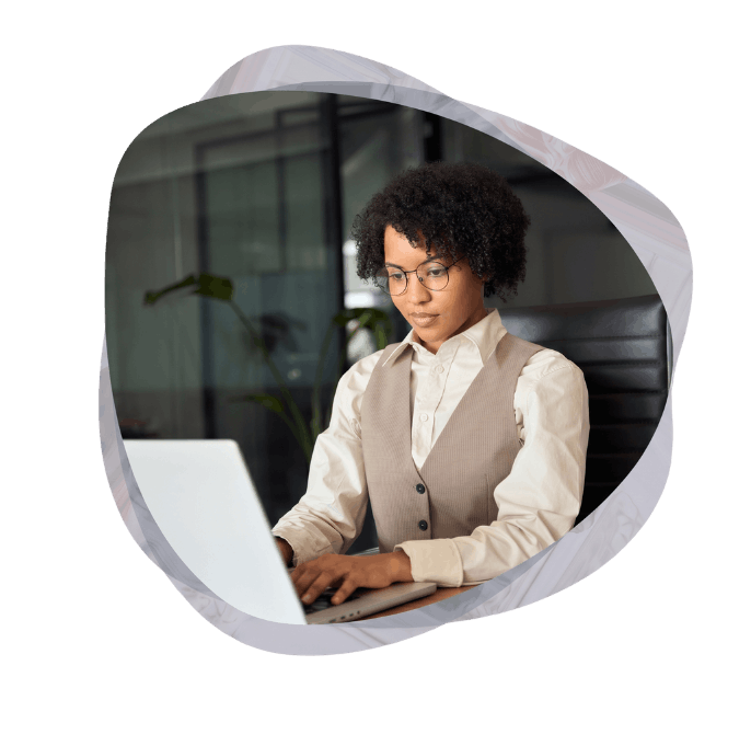 A focused businesswoman typing on a laptop at her desk, utilizing modern collaboration solutions to streamline her daily workflow.