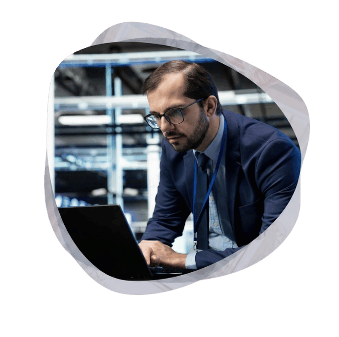 IT specialist working on a laptop in a data centre during an enterprise application migration to Azure.